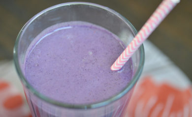 Purple-colored PB&J smoothie up close with a pink straw.