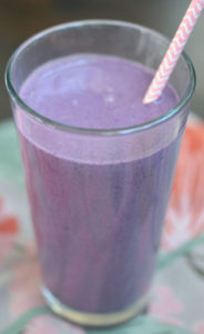 Tell peanut butter and jelly smoothie over flowery tapestry.