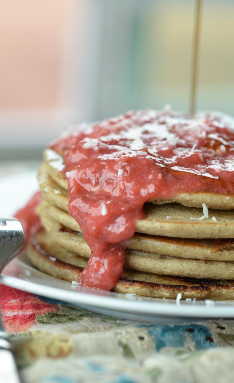 Oatmeal pancakes covered in strawberry puree and syrup.