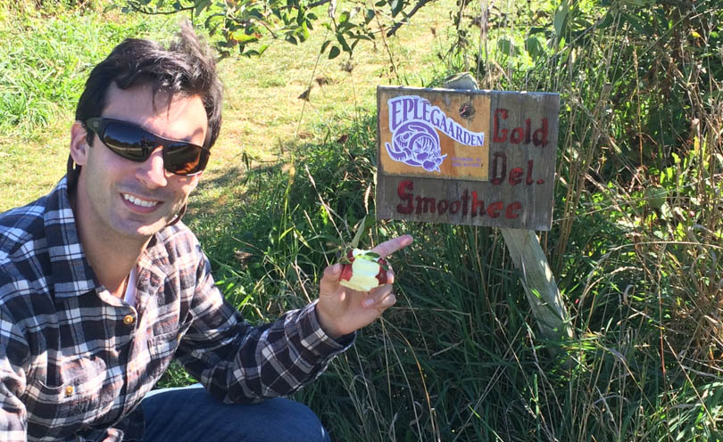 Lenny Gale in front of sign at apple orchard saying smoothie sign