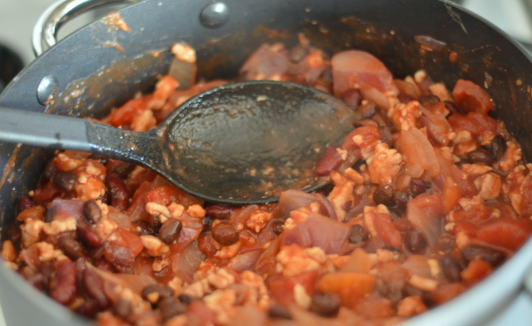 Serving spoon in big pot of five alarm chili