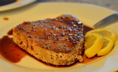 Ahi Tuna Served on white plate with soy sauce and lemon wedge
