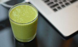 Green smoothie next to my laptop for Vitamix vs Blendtec