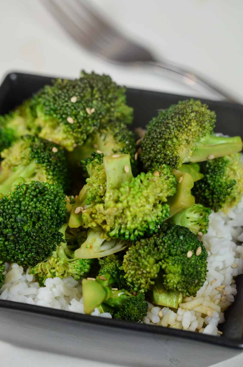 Broccoli sauteed in soyaki sauce with a fork on the side.