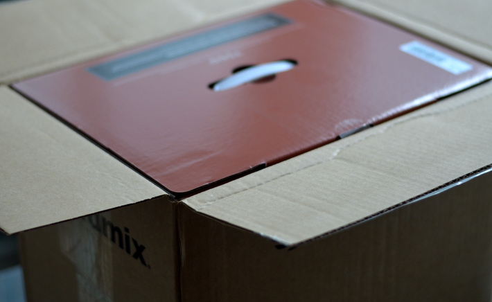 cardboard box opened exposing maroon vitamix 7500 box