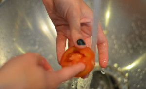 Poking out seeds under water for how to cut tomatoes for salad