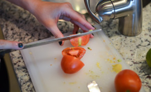 Slicing tomatoes equator style before gutting them for salad slices