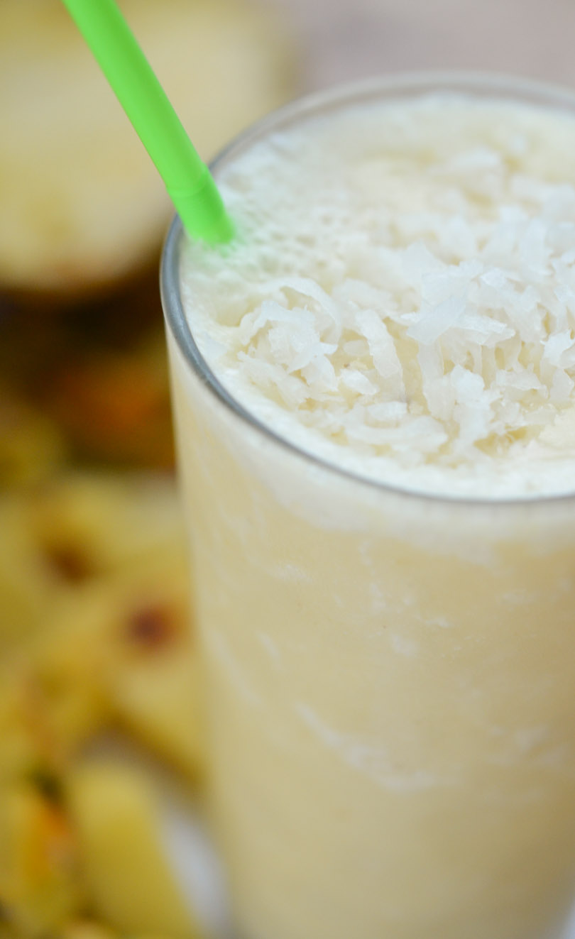 Pina colada smoothie with pineapple in background.