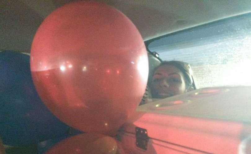 Red balloon and Shalva packed in car.