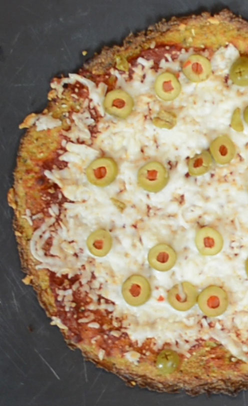 Overhead view of of green olive cauliflower crust pizza.