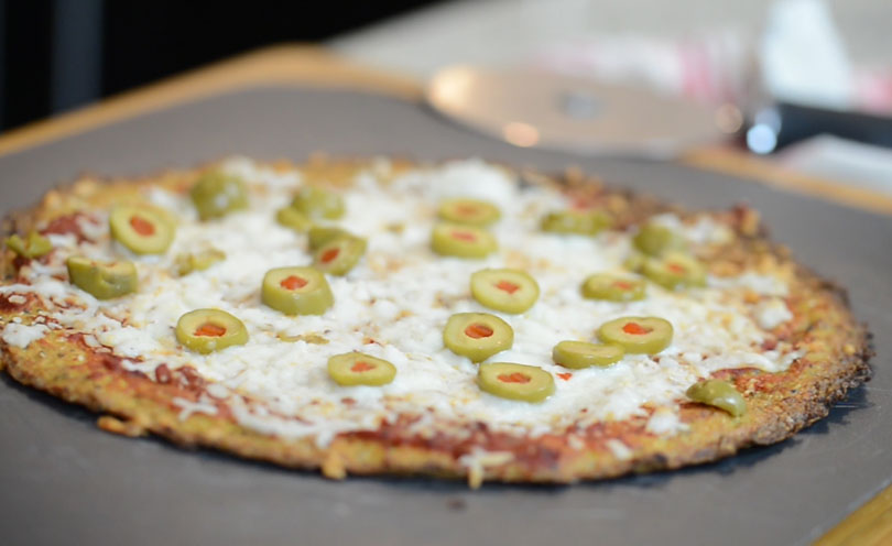 Cauliflower pizza crust served as a green olive pizza.