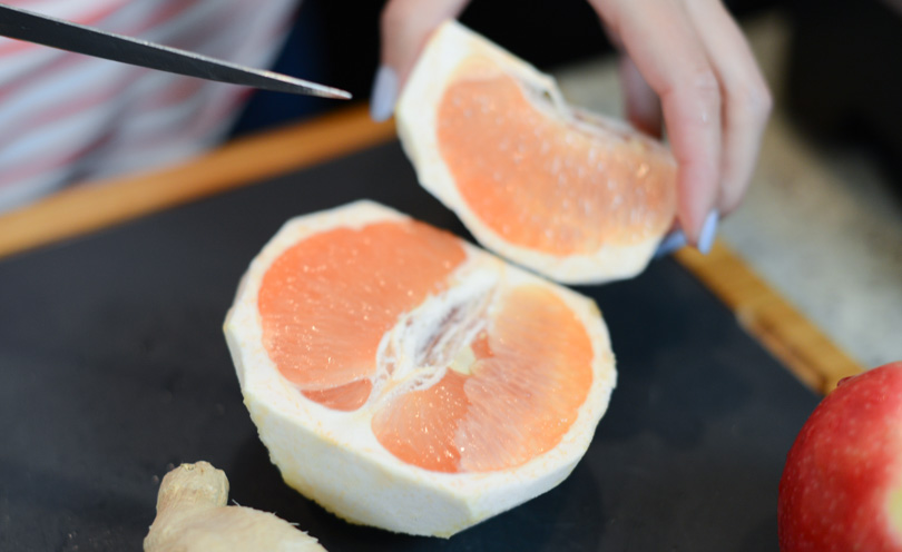 Slicing grapefruit for a grapefruit, ginger and apple for a smoothie called The Pinkman.
