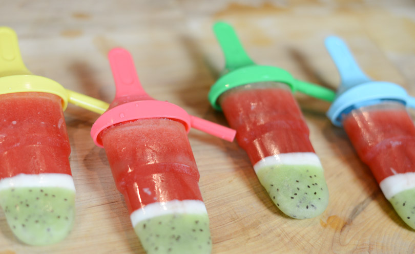 Watermelon kiwi coconut popsicles up close and staggered.