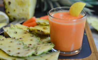 Invigorating pineapple-based, citrus carrot juice served with slice of lemon.