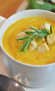 Butternut squash soup served with rosemary and tofu garnish.
