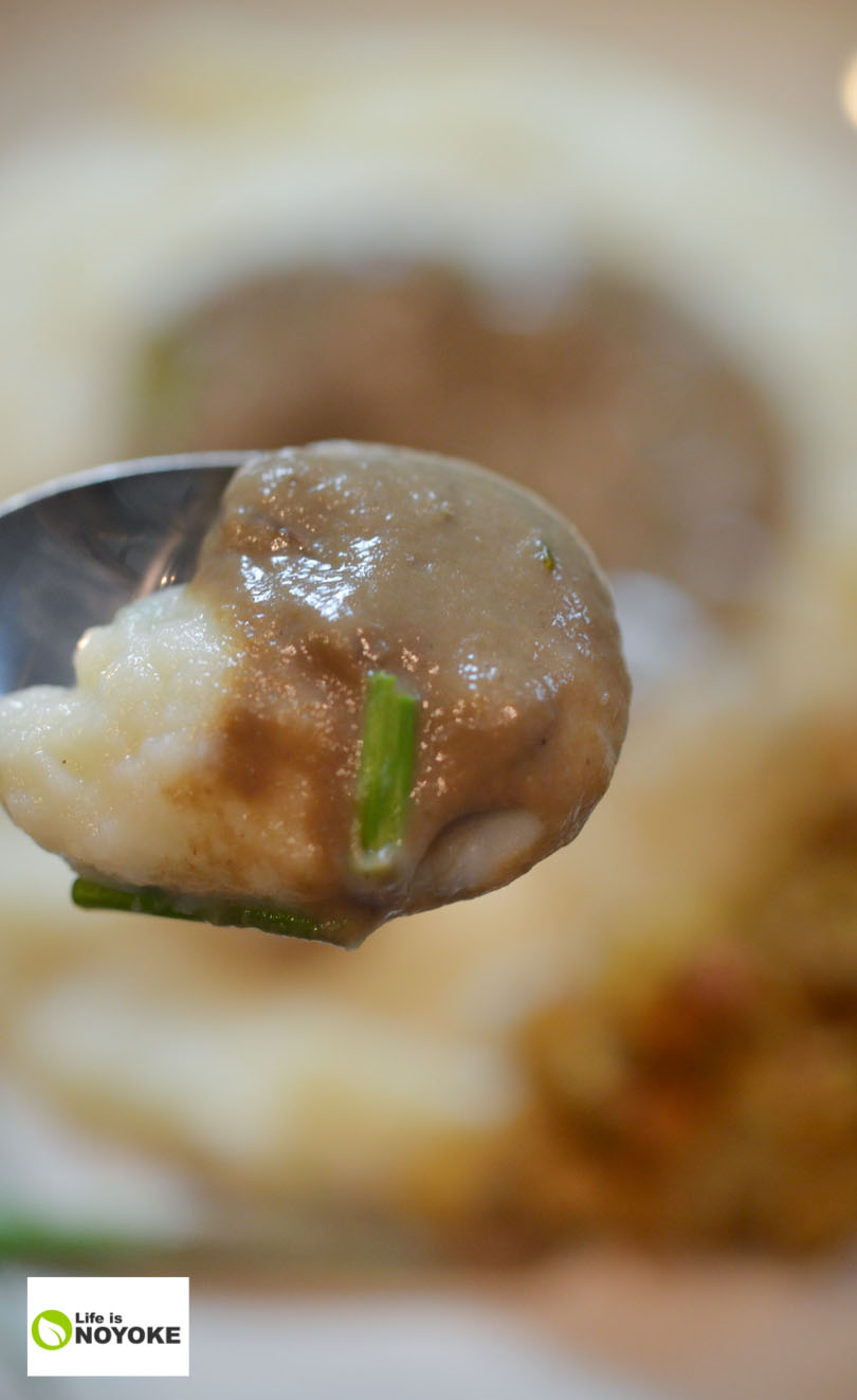 Vegan mushroom gravy up close on a spoon.