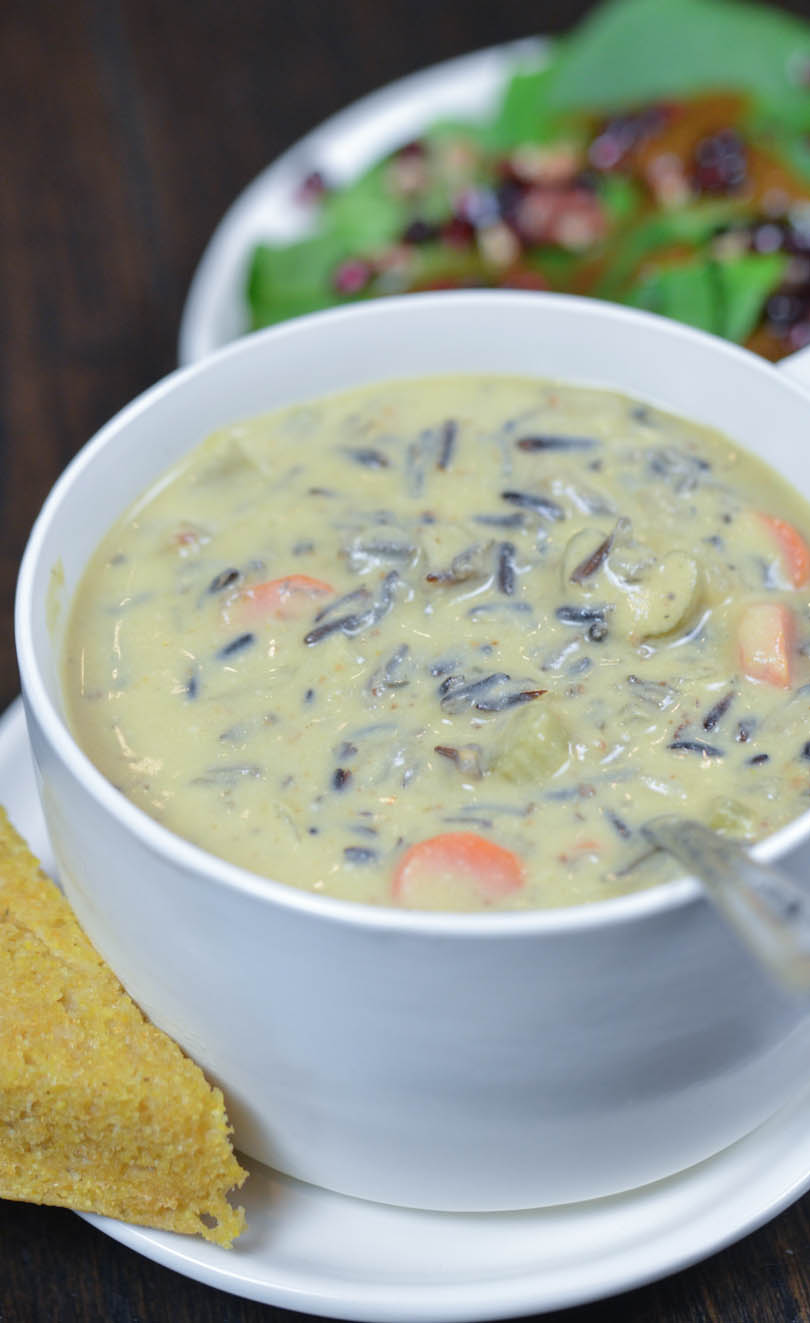 Vegan, chunky, creamy wild rice soup steaming hot served with corn bread and salad.