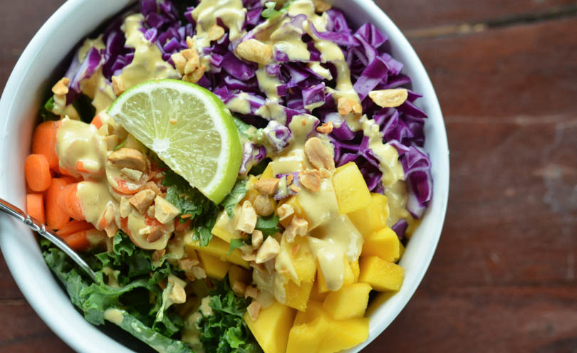 Thai coconut curry dressing served on kale carrot mango cabbage salad.