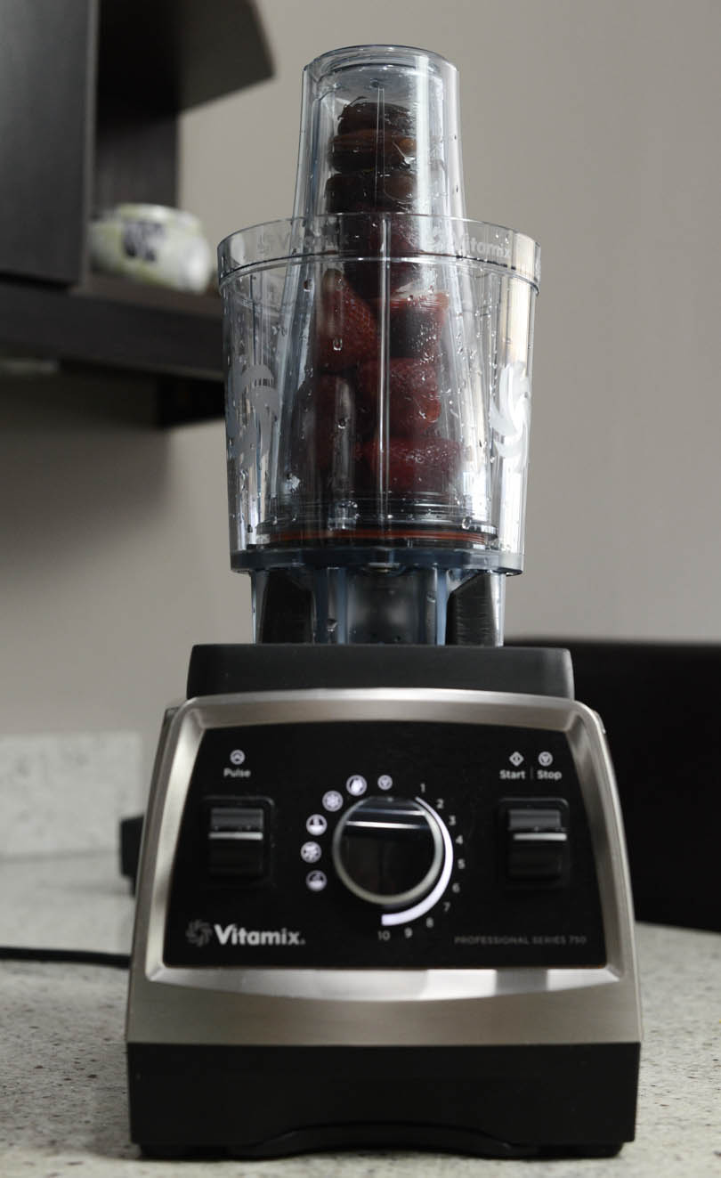 Vitamix 20 oz Personal Cup Adapter on a Pro 750 with strawberries and dates inside.