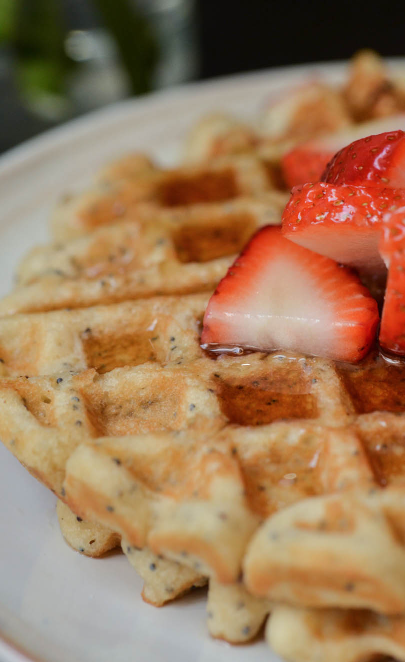 Close up of waffles with poppy seeds and lemon.