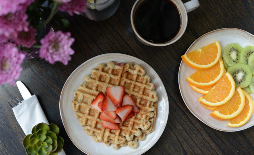 Waffles served for Mother's Day with flowers and coffee and fruit.