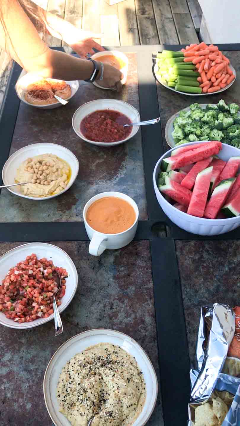Spread of hummus, salsa, queso, watermelon, and veggies.