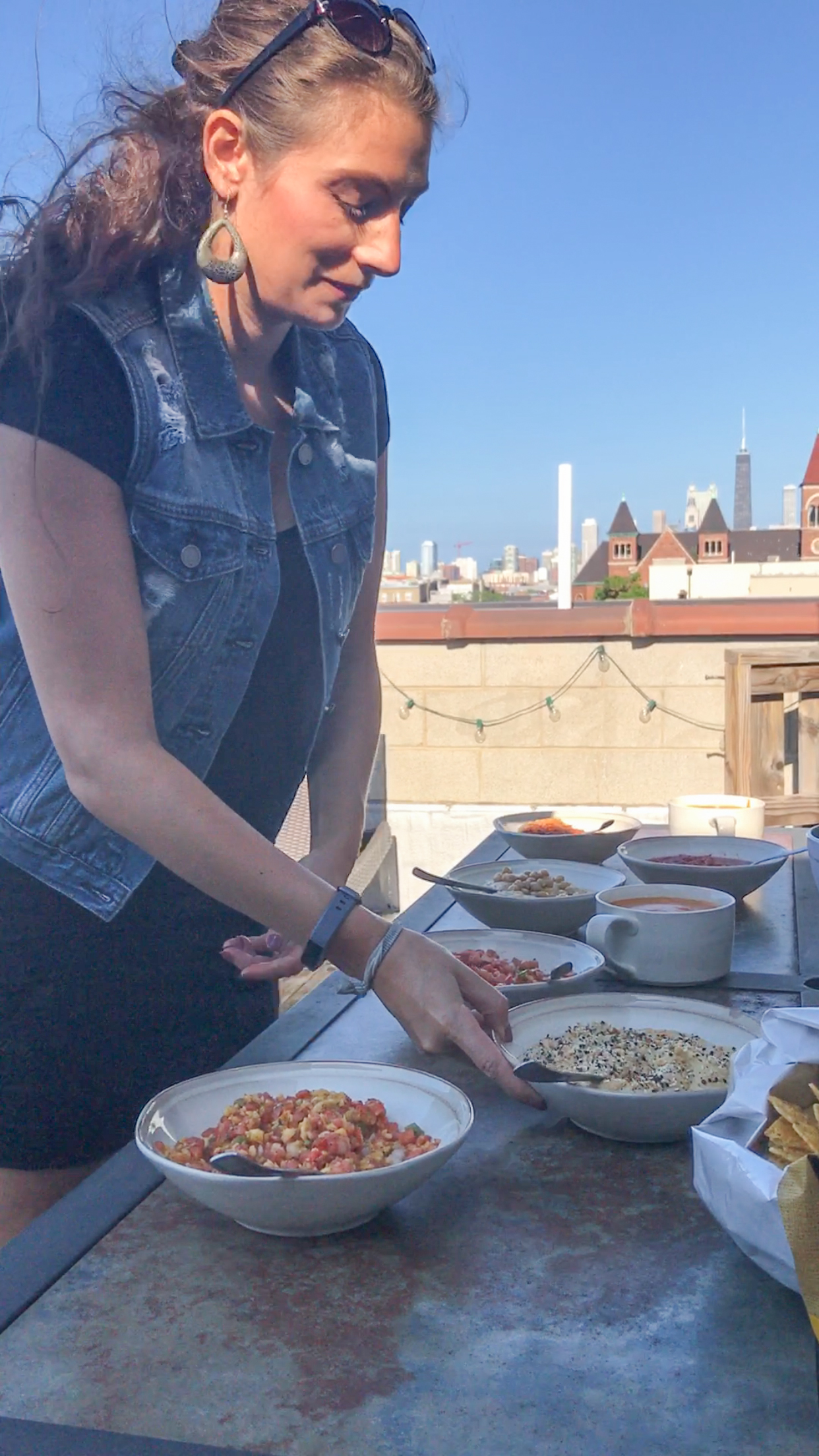 Shalva on our Chicago rooftop serving hummus, salsa, queso and veggies.
