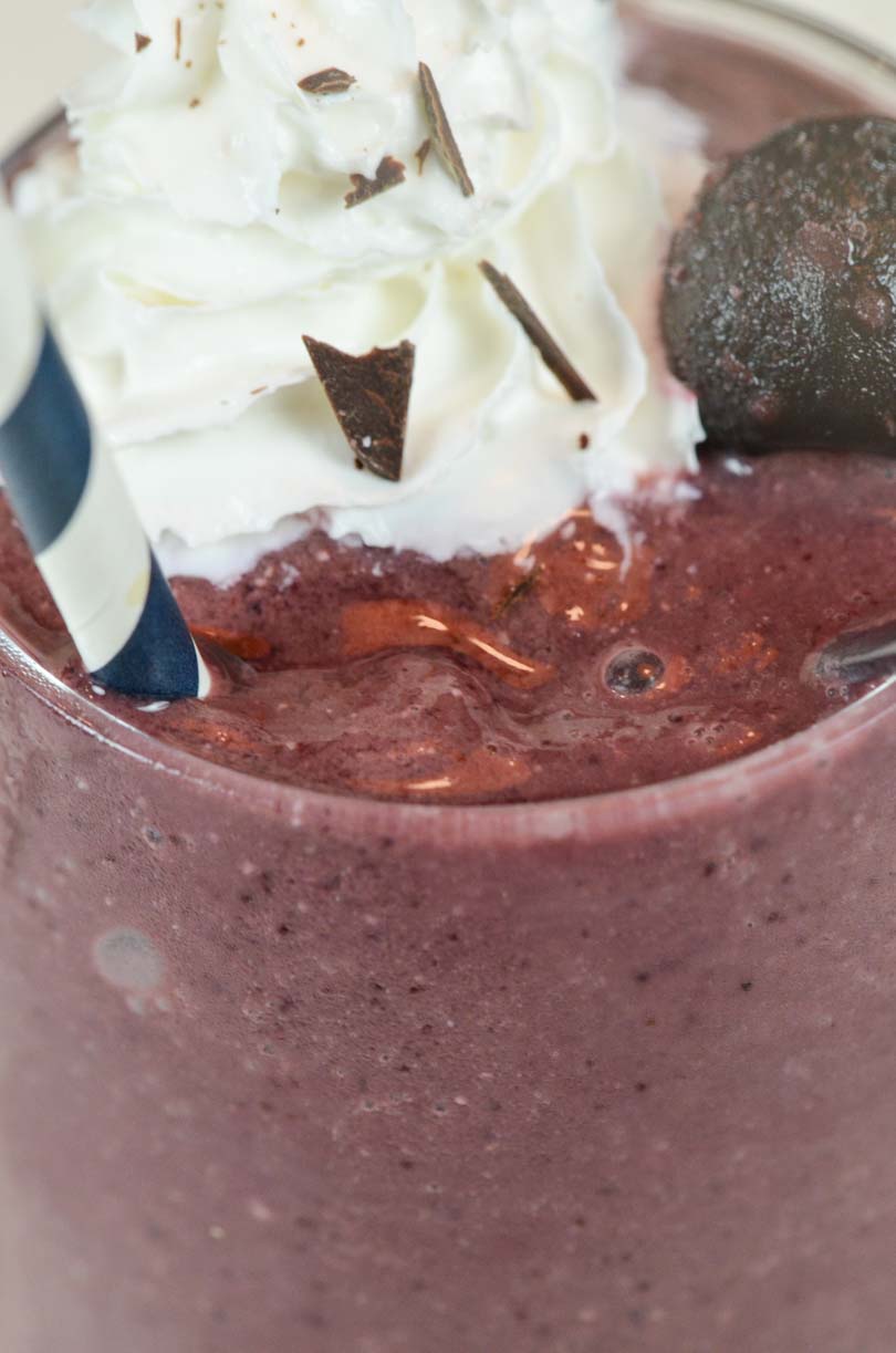 Red velvet shake with whip cream and chocolate shavings.