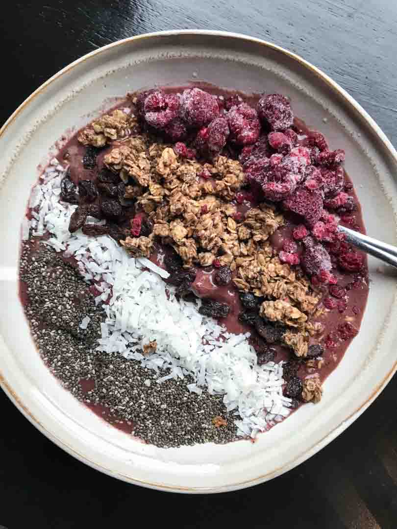 Red velvet shake as a smoothie bowl with granola, fruit and seeds.