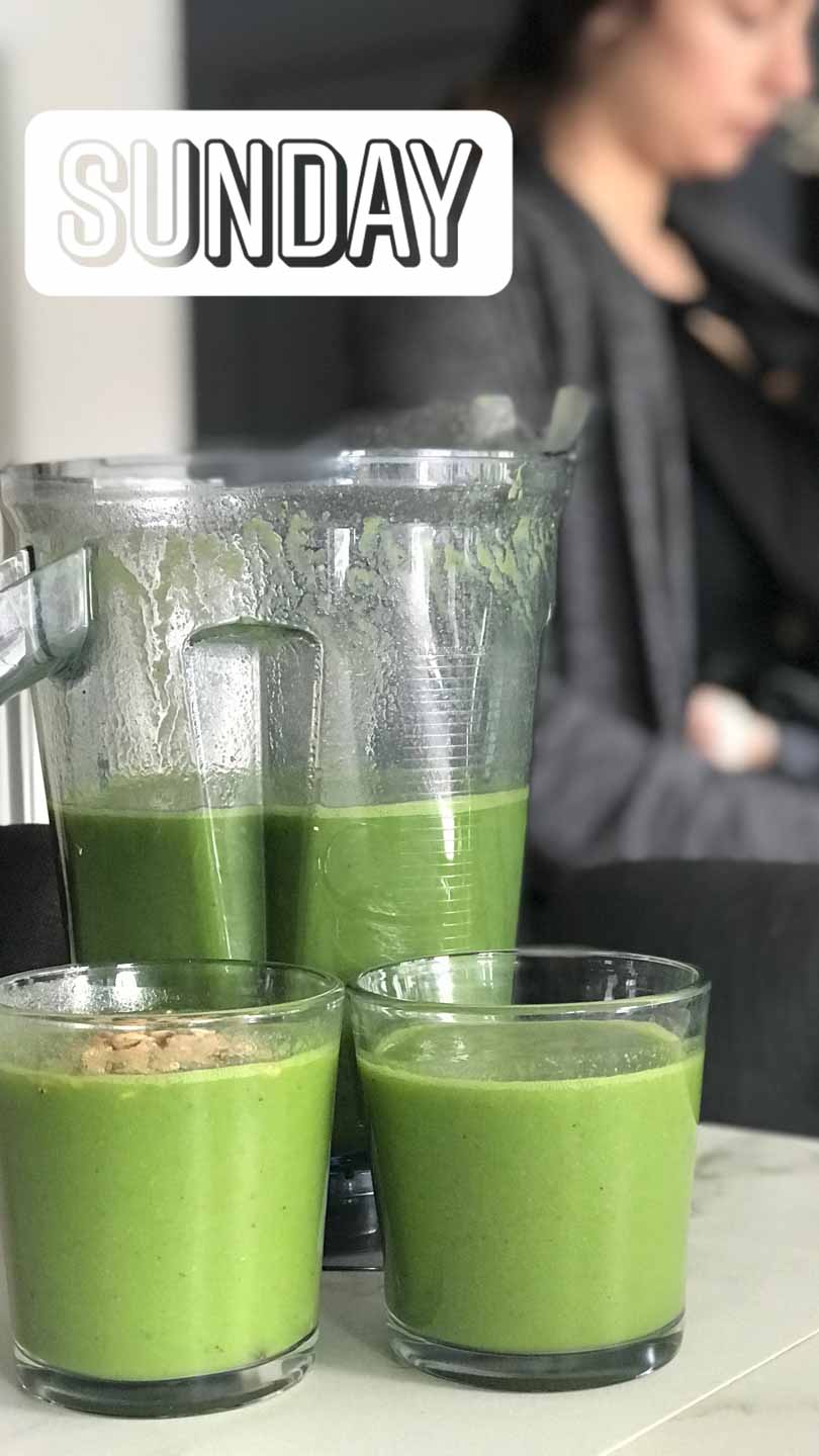 Green juice in short glasses and a Vitamix container.