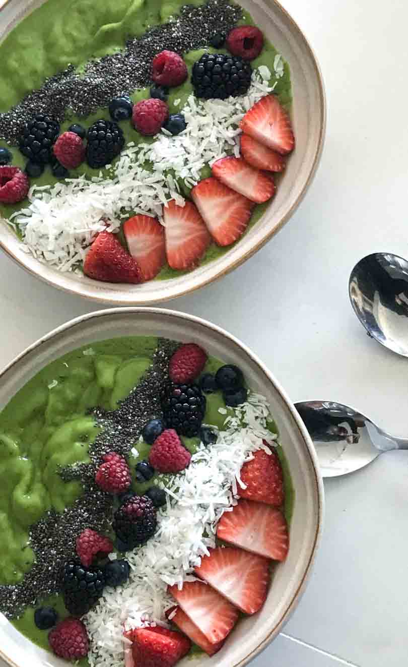 Green smoothie bowl with berry toppings.