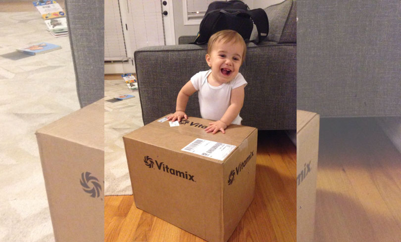 Baby with a Certified Reconditioned standard Programs Vitamix in box.