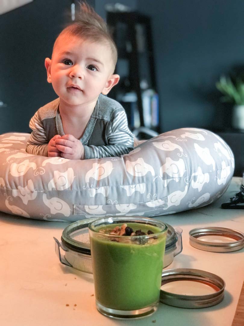 Baby with green juice from a Vitamix.