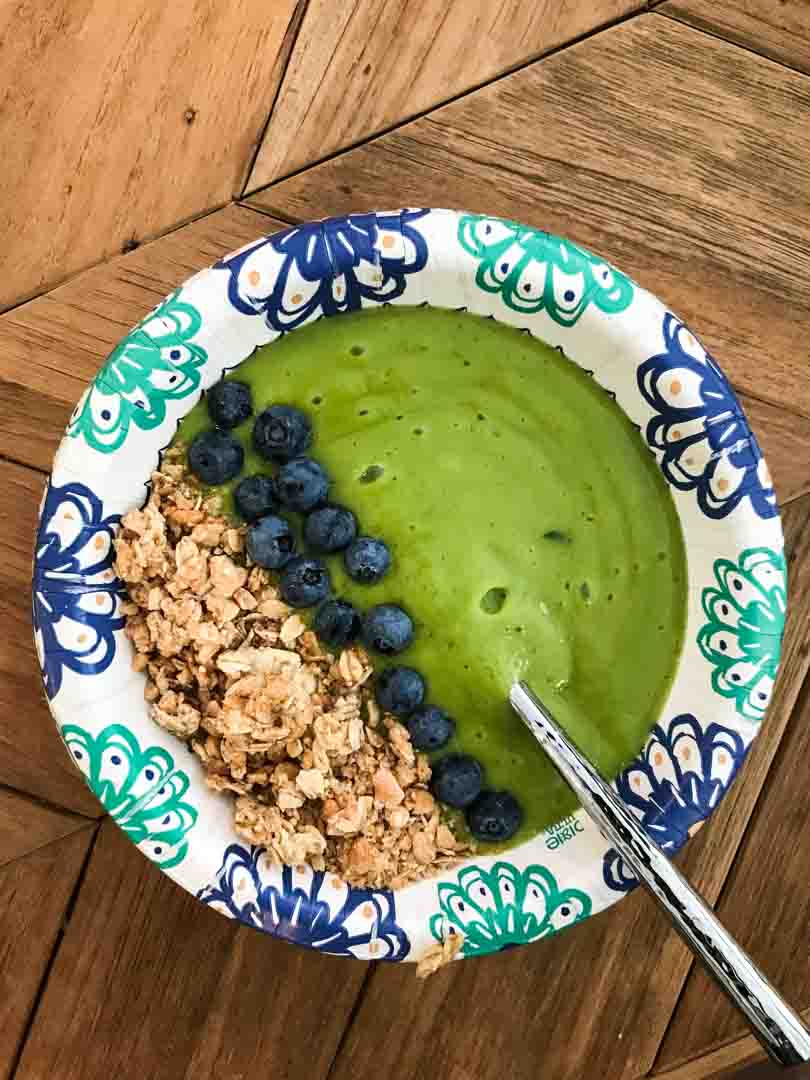 Green smoothie bowl with blueberries and granola.